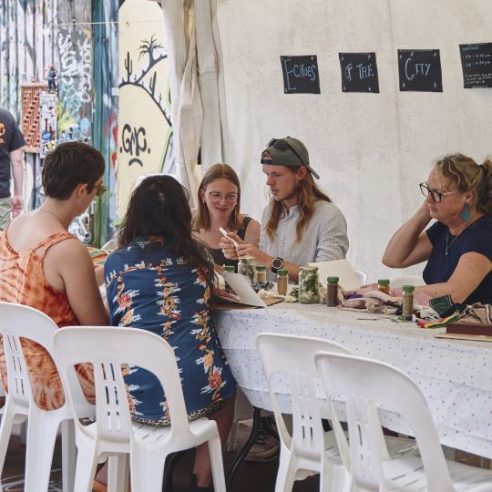 Five people sitting at a table, engaged in a creative workshop